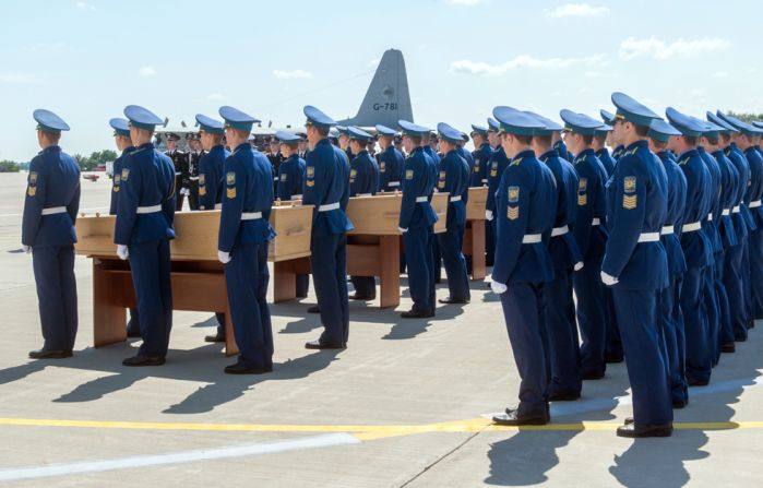 Ukrainian soldiers stand next to coffins carrying the remains of the victims during a ceremony at Kharkiv airport.