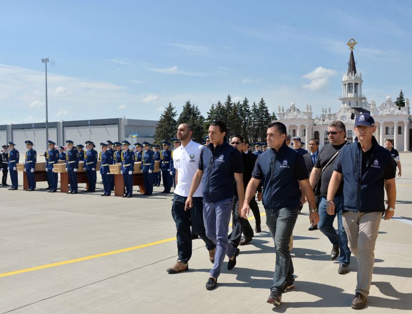 International experts march towards a plane at Kharkiv airport to accompany the remains of victims to the Netherlands.