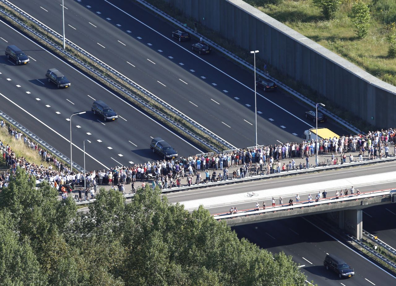 This aerial photo shows people watching from a bridge as a convoy of hearses makes its way from Eindhoven air base to Hilversum.