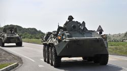 Two Russian armored personal carriers roll near the border with Ukraine outside the Russian town of Donetsk in Rostov-on-Don region, Sunday, July 13, 2014. Russia's foreign ministry said Sunday that a Ukrainian shell hit a town on the Russian border, killing one person and seriously injuring two others. But Ukraine denied firing a shell into Russian territory. (AP Photo/Sergei Pivovarov)