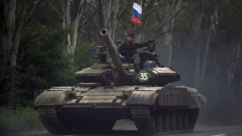 Pro-Russian rebels ride on a tank flying Russia's flag, on a road east of Donetsk, Monday, July 21, 2014. Another 21 bodies have been found in the sprawling fields of east Ukraine where Malaysia Airlines Flight 17 was downed last week, killing all 298 people aboard. International indignation over the incident has grown as investigators still only have limited access to the crash site and it remains unclear when and where the victims' bodies will be transported. (AP Photo/Vadim Ghirda)