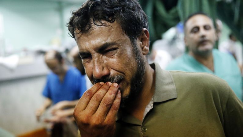 A Palestinian man cries after bringing a child to the Kamal Adwan hospital in Beit Lahiya on Thursday, July 24. The child was wounded in <a href="index.php?page=&url=http%3A%2F%2Fwww.cnn.com%2F2014%2F07%2F24%2Fworld%2Fmeast%2Fmideast-crisis%2Findex.html">a strike on a school</a> that was serving as a shelter for families in Gaza. It's unclear who was behind the strike. The Israeli military said it was "reviewing" the incident, telling CNN that a rocket fired from Gaza could have been responsible.