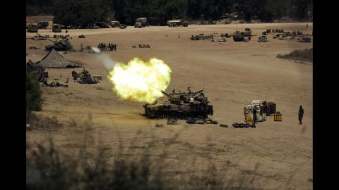 An Israeli tank fires toward Gaza from a position near Israel's border on July 24.