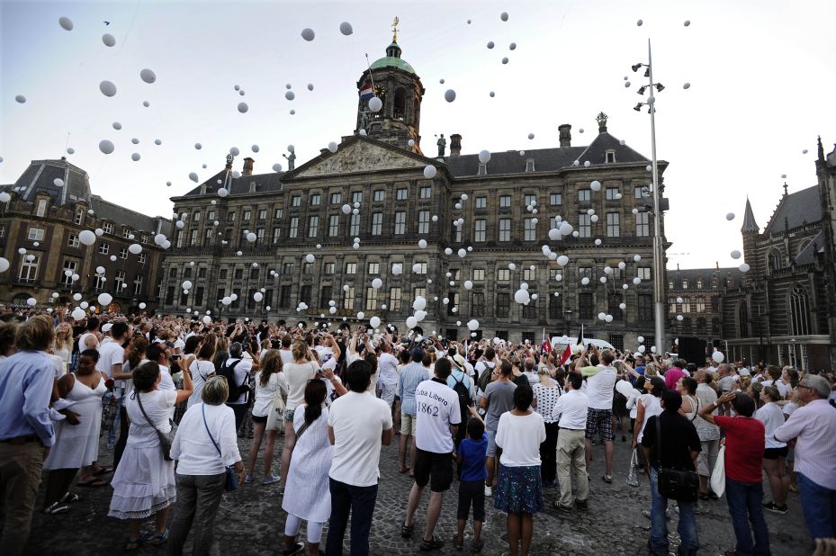 White balloons are released in the air.