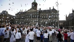 People release white balloons in the air during a silent march in memory of the victims of the downed Malaysia Airlines flight MH17, on July 23, 2014 in Amsterdam.