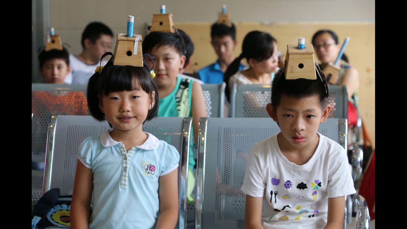 Children wear moxibustion boxes on their heads Friday, July 18, at a hospital in Qingdao, China. Moxibustion is a traditional Chinese medical treatment that involves the burning of moxa, or mugwort. According to the <a href="http://www.cancer.org/treatment/treatmentsandsideeffects/complementaryandalternativemedicine/manualhealingandphysicaltouch/moxibustion" target="_blank" target="_blank">American Cancer Society</a>, practitioners believe the burning of the herbs can restore the balance and flow of vital energy, or chi. The children's treatment pictured here is part of an annual summer tradition to fend off winter diseases.