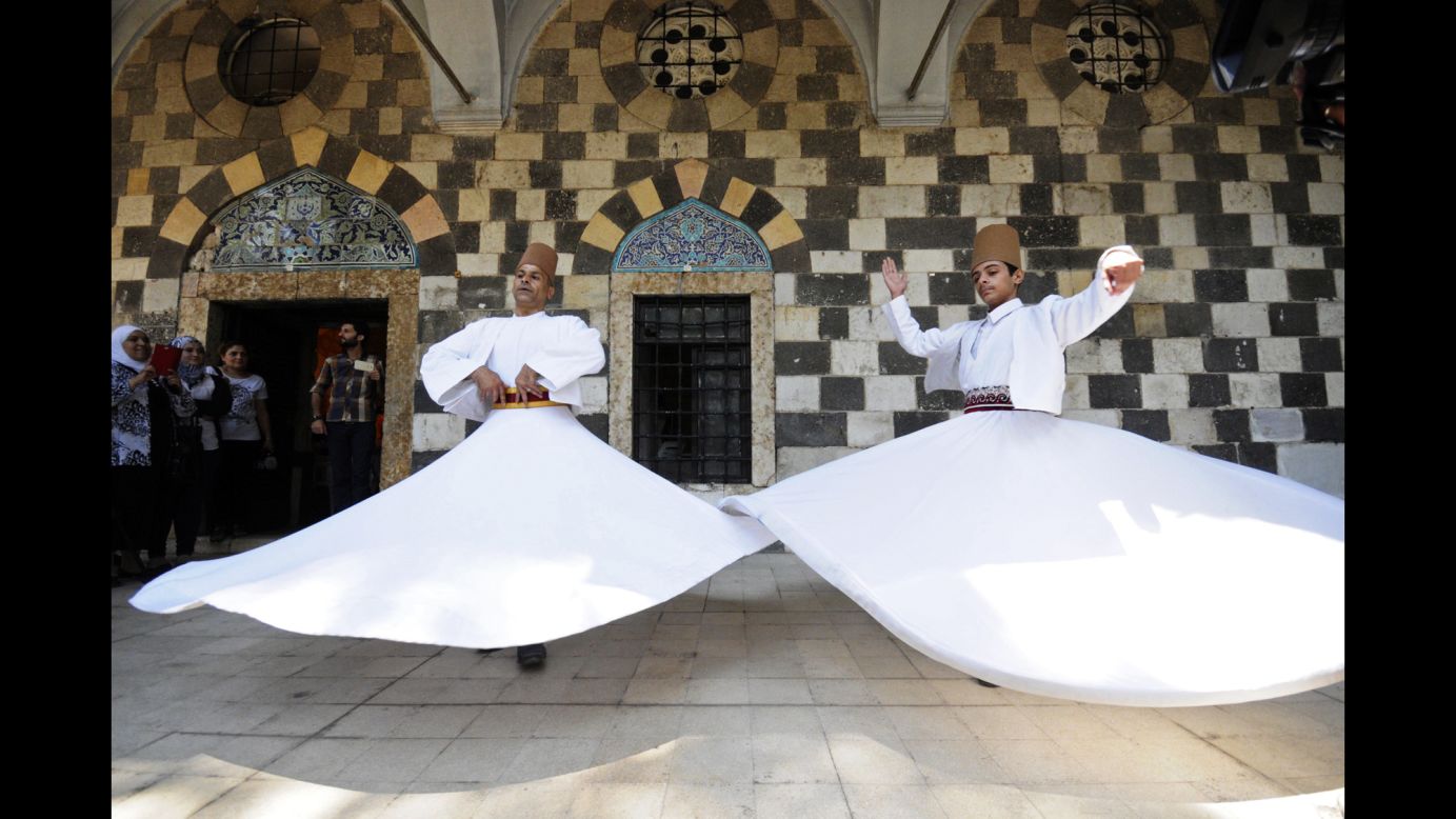 People watch the <a href="http://www.cnn.com/2014/07/24/travel/turkey-mevlevi-dervishes/index.html">"Whirling Dervishes"</a> perform a traditional Sufi dance at a mosque complex in Damascus, Syria, on Monday, July 21. Those in the Order of the Mevlevi, a Sufi sect from the 13th century, are known as "Whirling Dervishes." Through the practice of "sema," or listening, in a prayer-induced trance, they aim to act as a bridge between God and humankind.