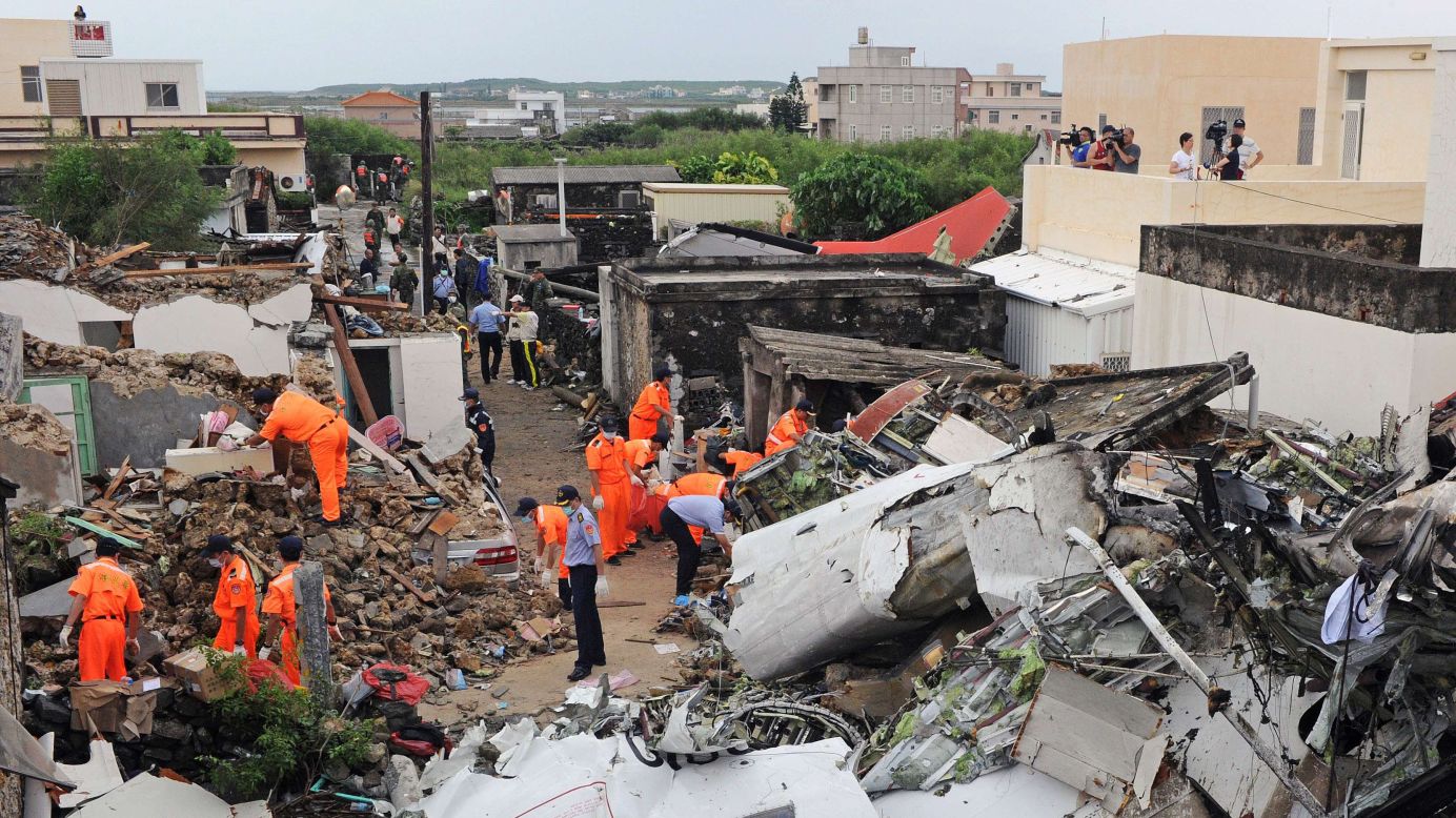 Rescue workers survey the wreckage of TransAsia Airways Flight GE222 on the Taiwanese island of Penghu on Thursday, July 24. The plane was attempting to land in stormy weather but <a href="http://www.cnn.com/2014/07/23/world/gallery/taiwan-plane-crash/index.html">crashed on the island</a> late Wednesday, killing at least 48 people and wrecking houses and cars on the ground.