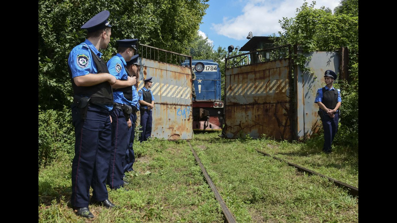 Police officers in Kharkiv, Ukraine, secure a refrigerated train loaded with victims of Malaysia Airlines Flight 17 on Tuesday, July 22.