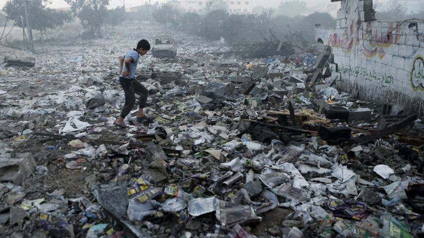 A Palestinian youth walks on debris as he inspects damages following an Israeli air strike in Gaza City, on July 24, 2014. Fifteen Palestinians were killed today when an Israeli shell slammed into a UN shelter where hundreds of civilians had taken refuge, sending the death toll in Gaza soaring to 788 despite world efforts to broker a ceasefire.