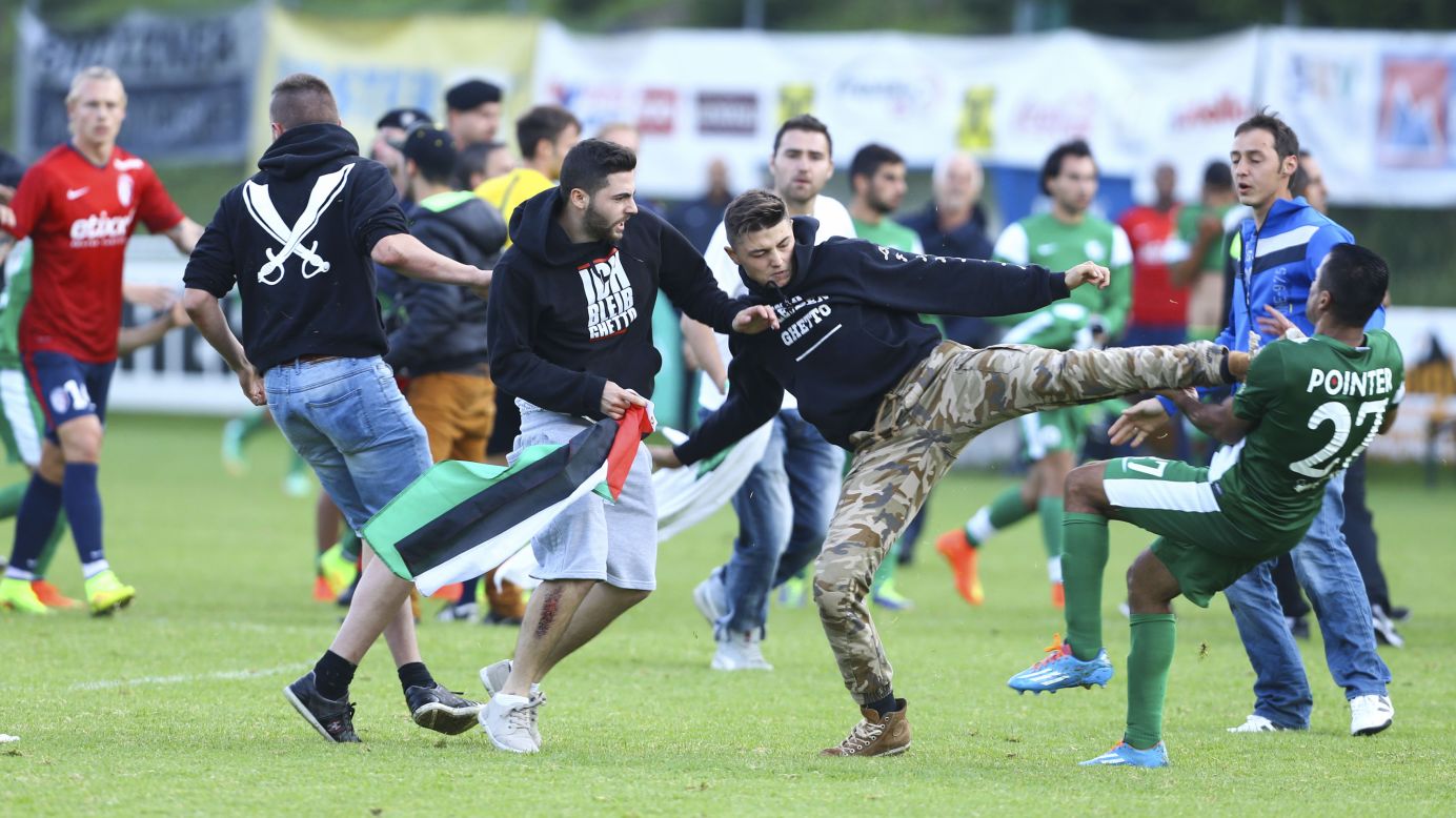 A Palestinian supporter kicks a member of the Israeli soccer team Maccabi Haifa on Wednesday, July 23, after protesters snuck onto the field during a preseason match against French club Lille OSC in Bischofshofen, Austria.