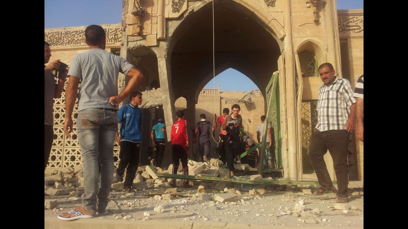 People inspect the destroyed mosque in Mosul. Militants overran Iraq's second-largest city in June and imposed their harsh interpretation of Islamic law.