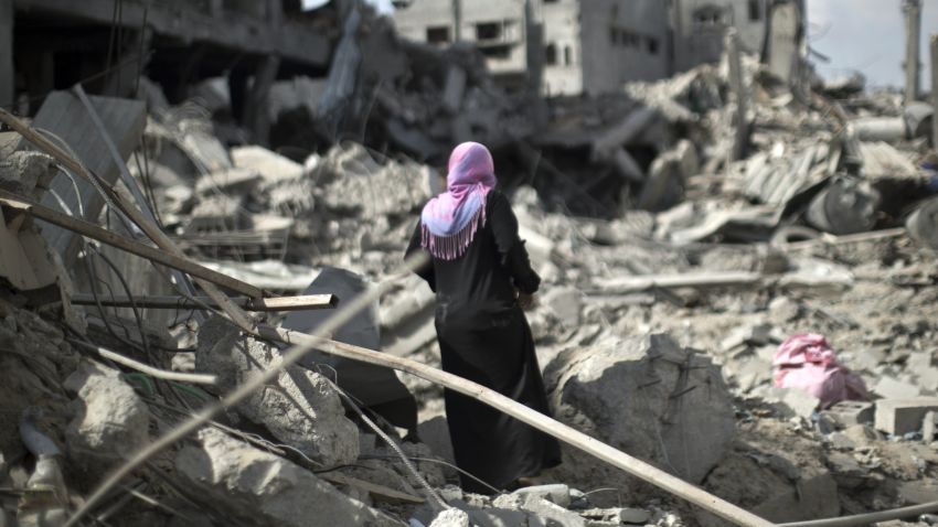 Caption:A Palestinian woman looks at the rubble of destroyed buildings and homes in the Shejaiya residential district of Gaza City on July 26, 2014. The bodies of at least 35 Palestinians were recovered from rubble across Gaza in the three hours since a humanitarian truce came into effect, raising to over 900 the overall death toll of Israel's onslaught on the territory since July 8, medics said. Thirteen bodies were recovered in Shejaiya in eastern Gaza City, 13 more in Deir al-Balah and Nusseirat in central Gaza, and nine in north Gaza. AFP PHOTO/MAHMUD HAMS (Photo credit should read MAHMUD HAMS/AFP/Getty Images)