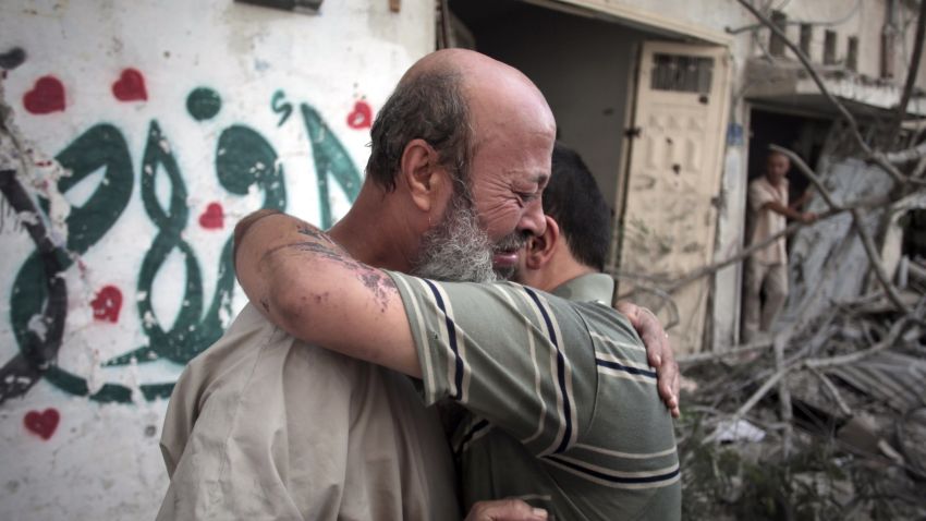 Palestinians hug each other after seeing their homes destroyed, during a 12-hour cease-fire in Gaza City's Shijaiyah neighborhood, Saturday, July 26, 2014. Gaza residents used a 12-hour humanitarian cease-fire on Saturday to stock up on supplies and survey the devastation from nearly three weeks of fighting, as they braced for a resumption of Israel's war on Hamas amid stalled efforts to secure a longer truce. (AP Photo/Khalil Hamra)