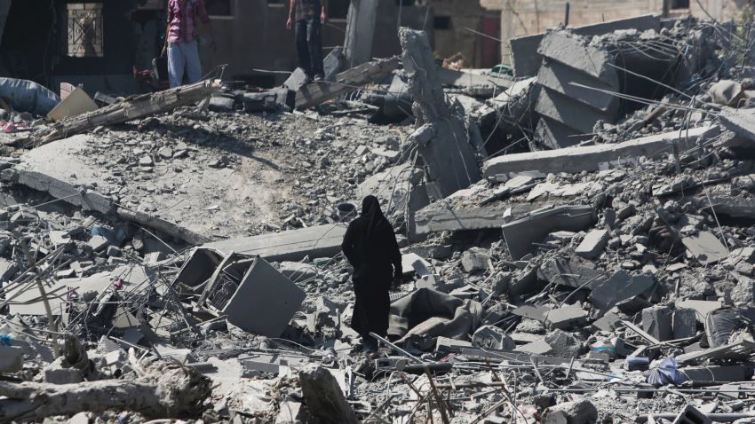 Palestinians through rubble on July 26 in Beit Hanoun.