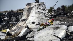 caption:This photo taken on July 26, 2014 shows flowers, left by parents of an Australian victim of the crash, laid on a piece of the Malaysia Airlines plane MH17, near the village of Hrabove (Grabove), in the Donetsk region. Ukraine sought on July 25 to avoid a political crisis after the shock resignation of its prime minister, as fighting between the army and rebels close to the Malaysian airliner crash site claimed over a dozen more lives. Dutch and Australian forces were being readied on July 26 for possible deployment to secure the rebel-held crash site of the Malaysia Airlines flight MH17 in east Ukraine where many victims' remains still lie nine days after the disaster claimed 298 lives. AFP PHOTO/ BULENT KILIC (Photo credit should read BULENT KILIC/AFP/Getty Images)