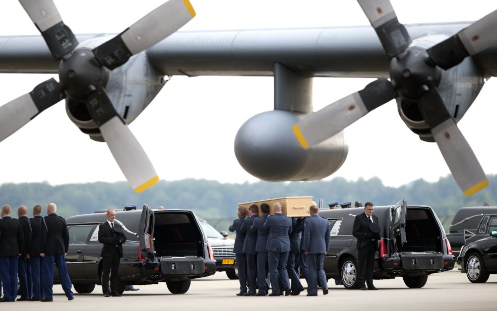 Dutch military personnel carry coffins to a waiting hearse at the Eindhoven airbase on Friday, July 25. 