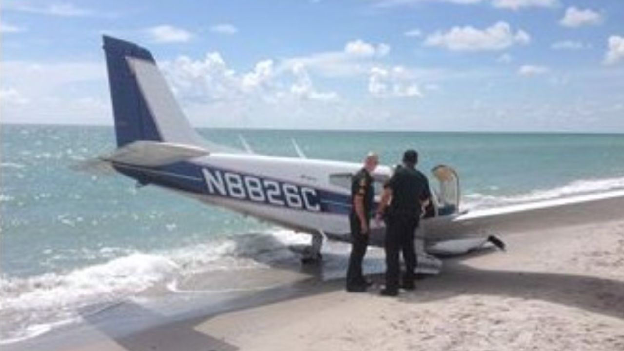 Sarasota County Sheriff's Office officials look over a plane that hit a father and daughter Sunday on a Florida beach.