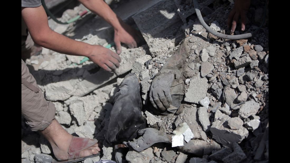 Palestinians dig a body out of the rubble of a destroyed house in Gaza during the cease-fire on July 26.