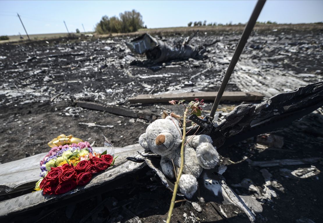 Flowers and a teddy bear, left by parents of an Australian victim of the crash, laid on a piece of the Malaysia Airlines plane MH17 in eastern Ukraine.