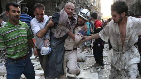 People carry an injured man away from the site of an airstrike, reportedly carried out by Syrian government forces, in Aleppo on Sunday, July 27.