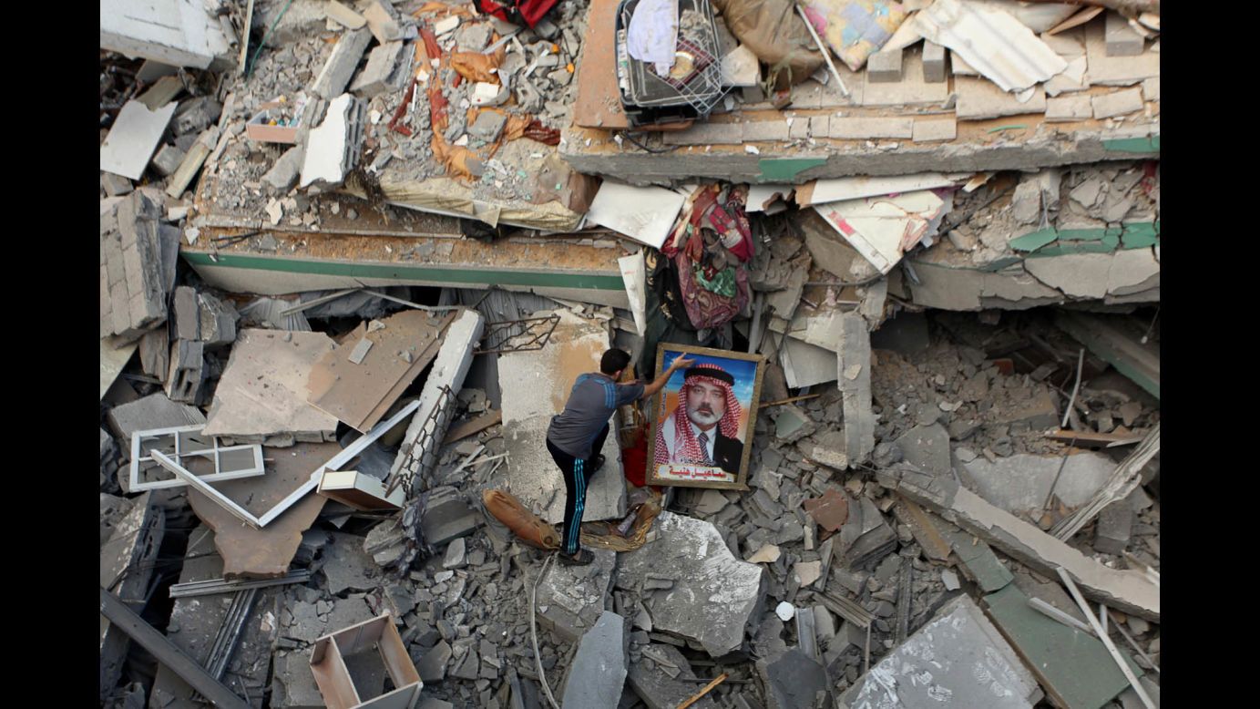 A Palestinian man places a portrait of Hamas leader Ismail Haniya on the rubble of Haniya's Gaza City home July 29 after it was hit by an overnight airstrike.