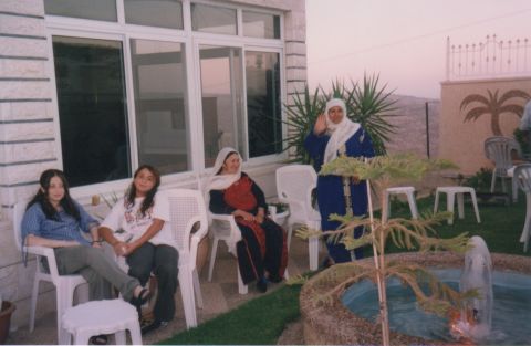 Naim Naif's grandmother, sister and cousin sit outside on the patio of the family's Palestinian home in 2000.
