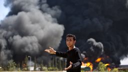 A Palestinian man reacts as flames engulf the fuel tanks of the only power plant supplying electricity to the Gaza Strip after it was hit by overnight Israeli shelling, on July 29, 2014, in the south of Gaza City.