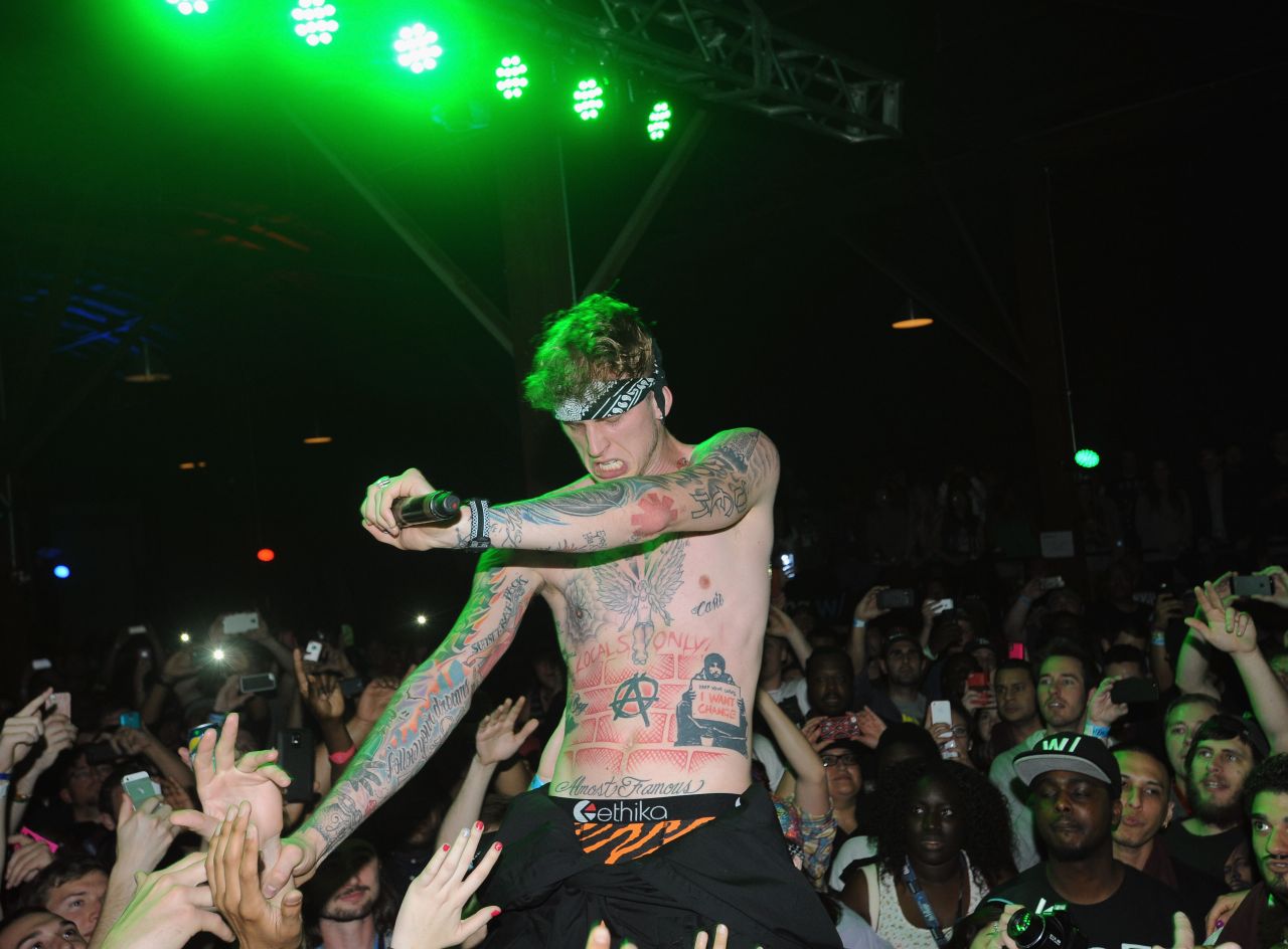 Rapper Machine Gun Kelly has inked nearly his entire body, including tattoos that are an ode to the famous book "1984" and his late grandmother. 