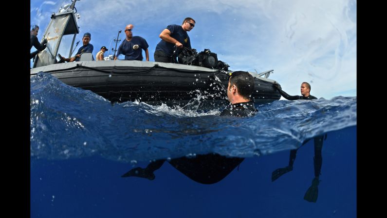 U.S. Navy divers from the Mobile Diving and Salvage Unit assist U.S. Coast Guard divers during an exercise on July 9.