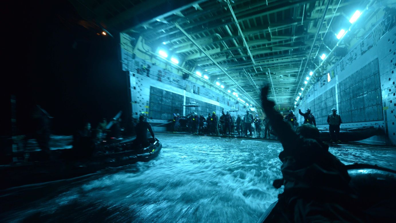 Members of the militaries of New Zealand, the Netherlands, Canada, Japan, Australia and Chile recover their boats into the well deck of the amphibious transport dock USS Anchorage after conducting night dive exercises off the coast of San Diego on July 18.