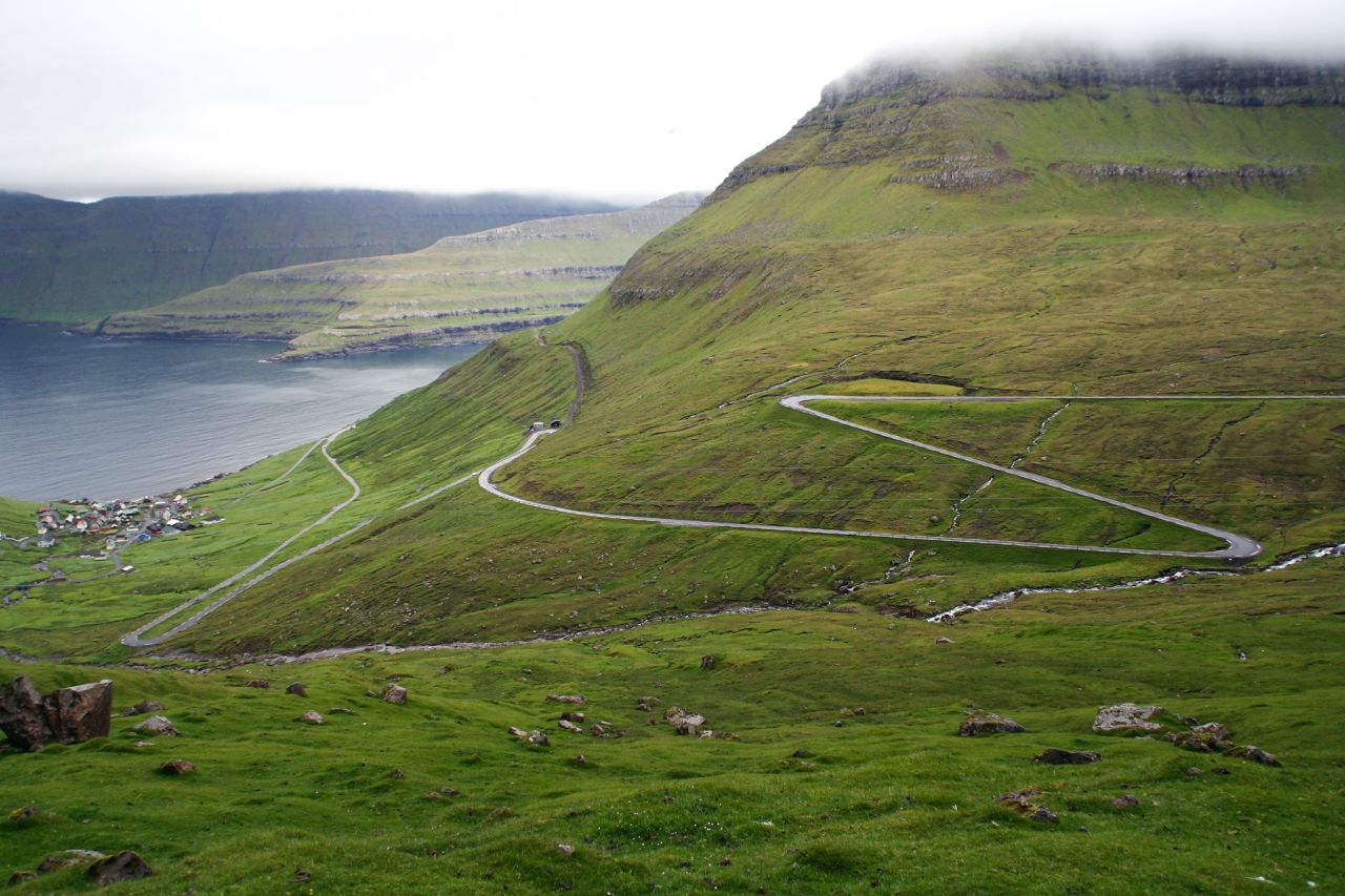 A narrow road from underneath Slættaratindur, the highest peak in the Faroe Islands, descends to Funningur in thrilling serpentine lanes. 