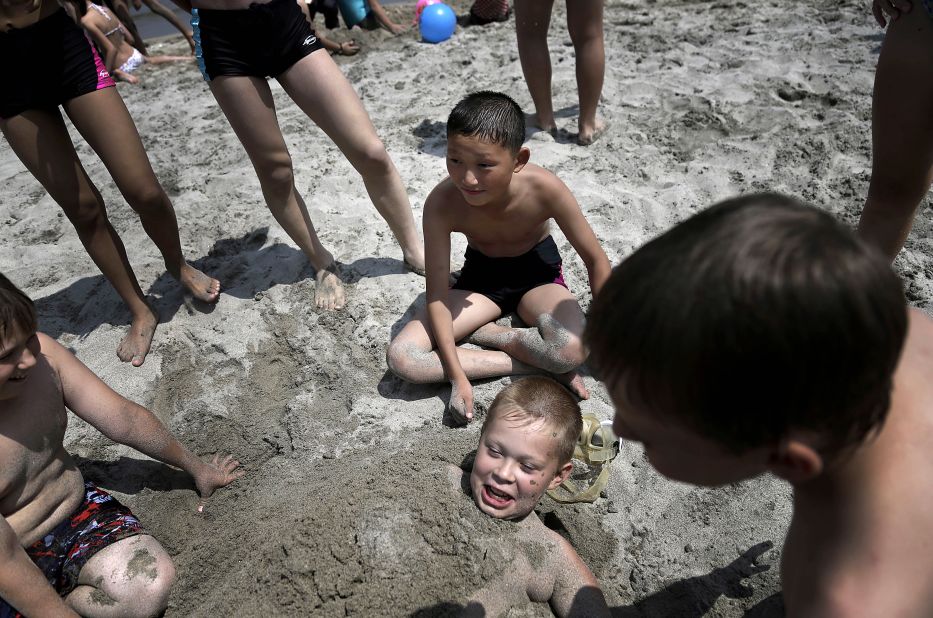 North Korean Kim Sun Gun, 12, smiles as Russian student Konstantin Kostya, 10, is buried in the sand. The camp was opened in the 1980s to foster ties with other communist-bloc countries. 