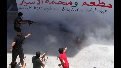Rebel fighters execute two men Friday, July 25, in Binnish, Syria. The men reportedly were charged by an Islamic religious court with detonating several car bombs. 