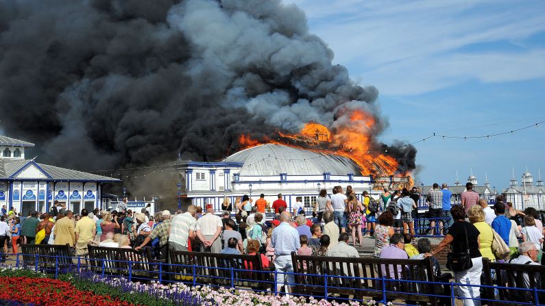 Onlookers watch a fire at the Eastbourne Pier in Eastbourne, England, on Wednesday, July 30.  
