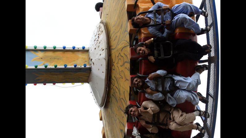 Pakistanis take a fairground ride during the<a href="http://religion.blogs.cnn.com/2014/06/28/the-belief-blog-guide-to-ramadan/"> Eid al-Fitr </a>holiday in Rawalpindi, Pakistan, on Tuesday, July 29.