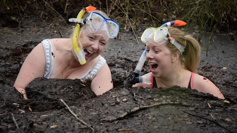Two women take a dip in the "Bog Jacuzzi" after taking part in the Irish Bog Snorkeling championship on Sunday, July 27, in Dungannon, Northern Ireland.