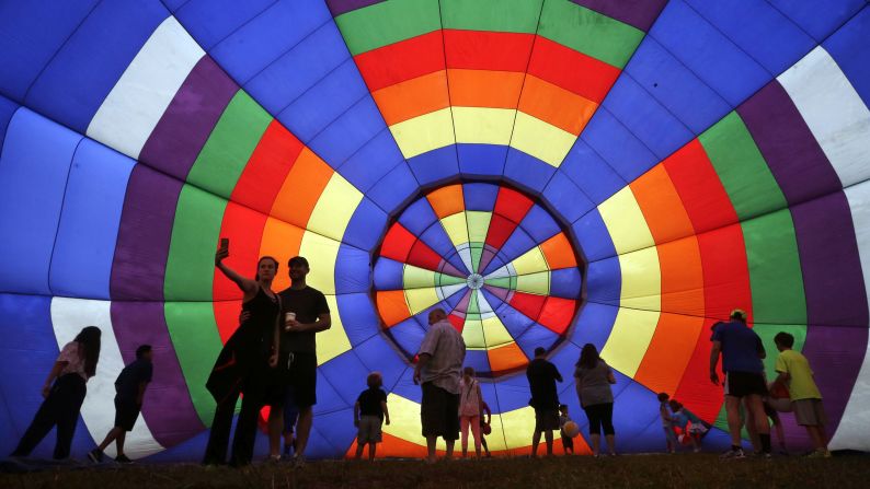 People walk around inside a partially inflated hot air balloon at the 32nd annual QuickChek New Jersey Festival of Ballooning, on Sunday, July 27, in Readington, New Jersey.