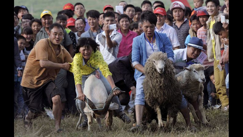 Contestants ride goats and sheep during a race to celebrate a festival in Fengshan, Guizhou province, China, on Saturday, July 26.