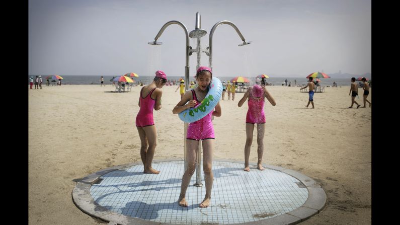 North Korean girls in similar bathing suits stand under a shower at the Songdowon International Children's Camp on Tuesday, July 29 in Wonsan, North Korea.