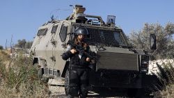 A female Israeli soldier stands next to an armoured vehicle during clashes with Palestinian protesters following a demonstration in the West Bank village of Bilin, on July 31, 2014, in support of Palestinians from the Gaza Strip. Israel vowed it would not pull troops out of Gaza until they finish destroying a network of cross-border tunnels, despite sharp United Nations criticism over the Palestinian death toll. AFP PHOTO/ABBAS MOMANI (Photo credit should read ABBAS MOMANI/AFP/Getty Images)
