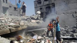 Palestinians extinguish a fire in the wreckage of a building, which was hit in an Israeli strike, in Rafah, in the southern Gaza Strip on August 2, 2014.
