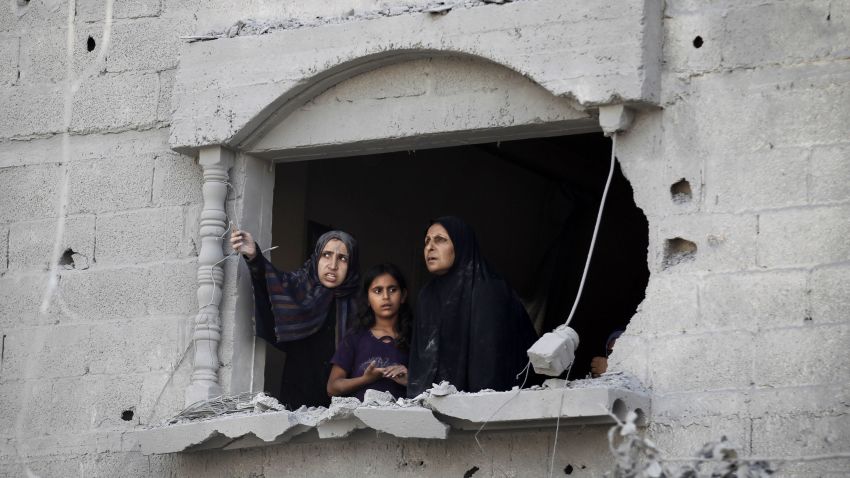 Palestinians look at the wreckage from a damaged window following an Israeli strike, in Rafah, in the southern Gaza Strip on August 2, 2014.