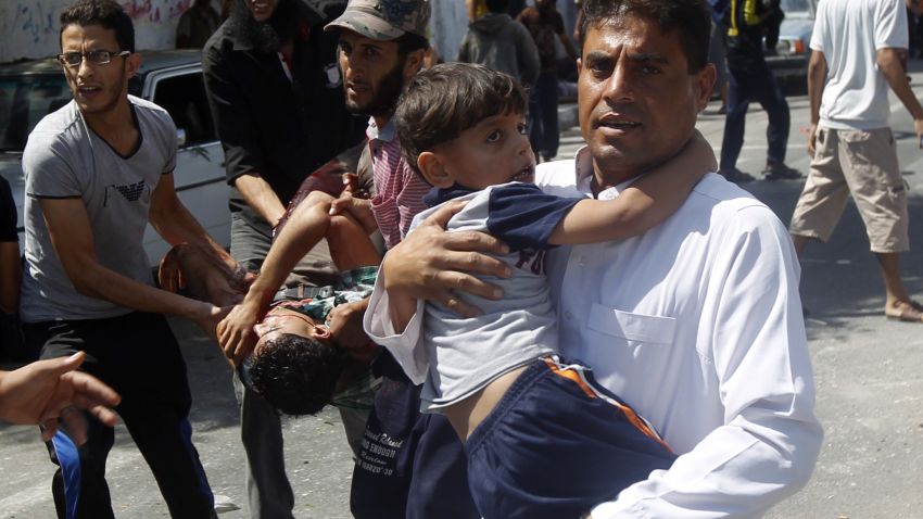 Palestinians carry injured people following an Israeli military strike on a UN school in Rafah, in the southern Gaza Strip on August 3, 2014. 