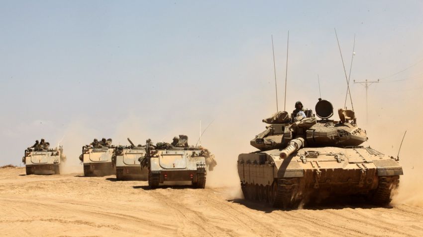 Israeli Merkava tanks and armored personnel carriers drive along the border between Israel and Gaza after pulling out of the Gaza  on August 3.