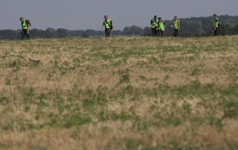 Australian and Dutch experts examine the area of the crash on August 3, 2014.