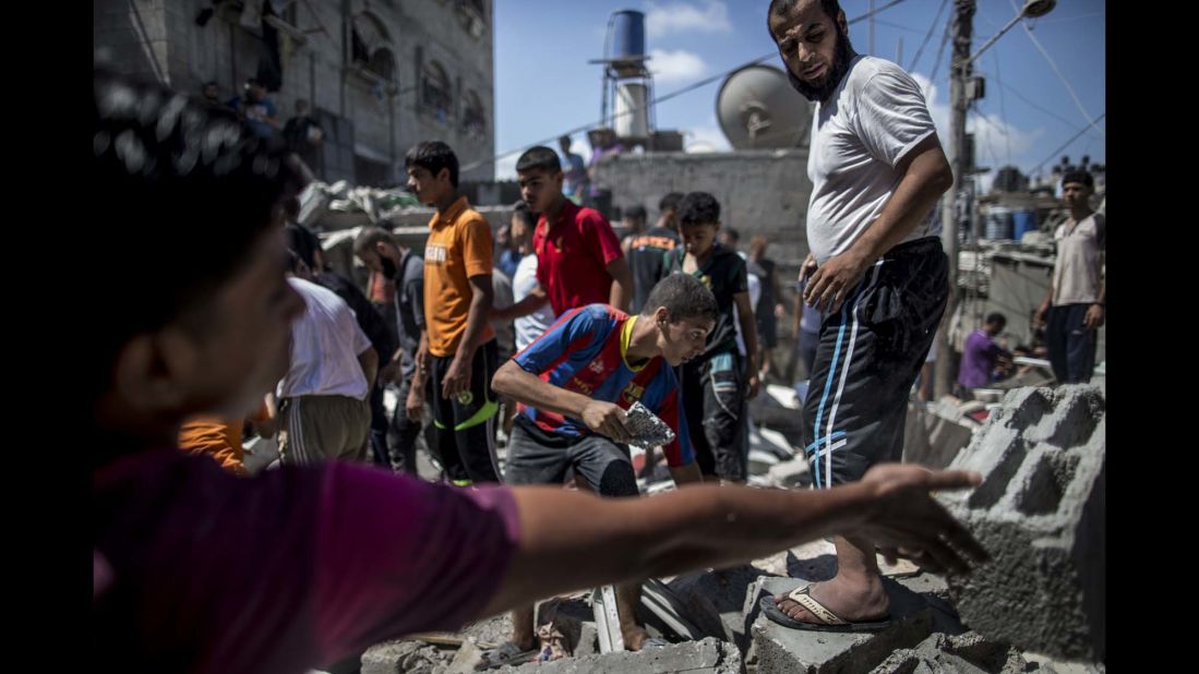 Palestinians remove rubble from a house hit by an airstrike in the al-Shati refugee camp in Gaza City on August 4.