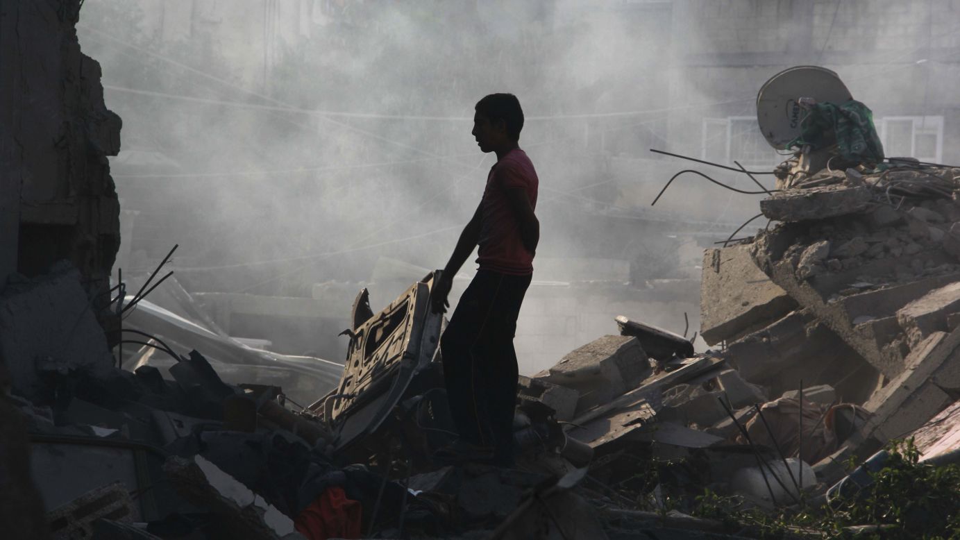 A Palestinian boy looks for belongings after an airstrike in Rafah on Saturday, August 2.