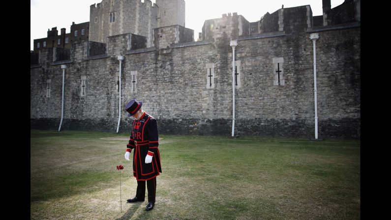 Crawford Butler, the longest serving Yeoman Warden at the Tower of London, poses with the first ceramic poppy on Thursday, July 17.