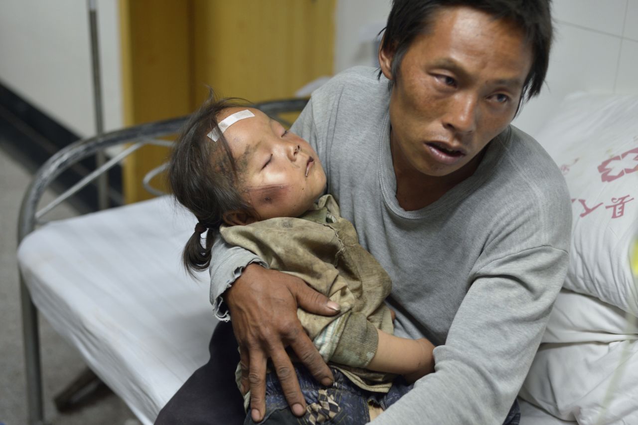 A man holds an injured child at a hospital in China's Ludian County on August 4.